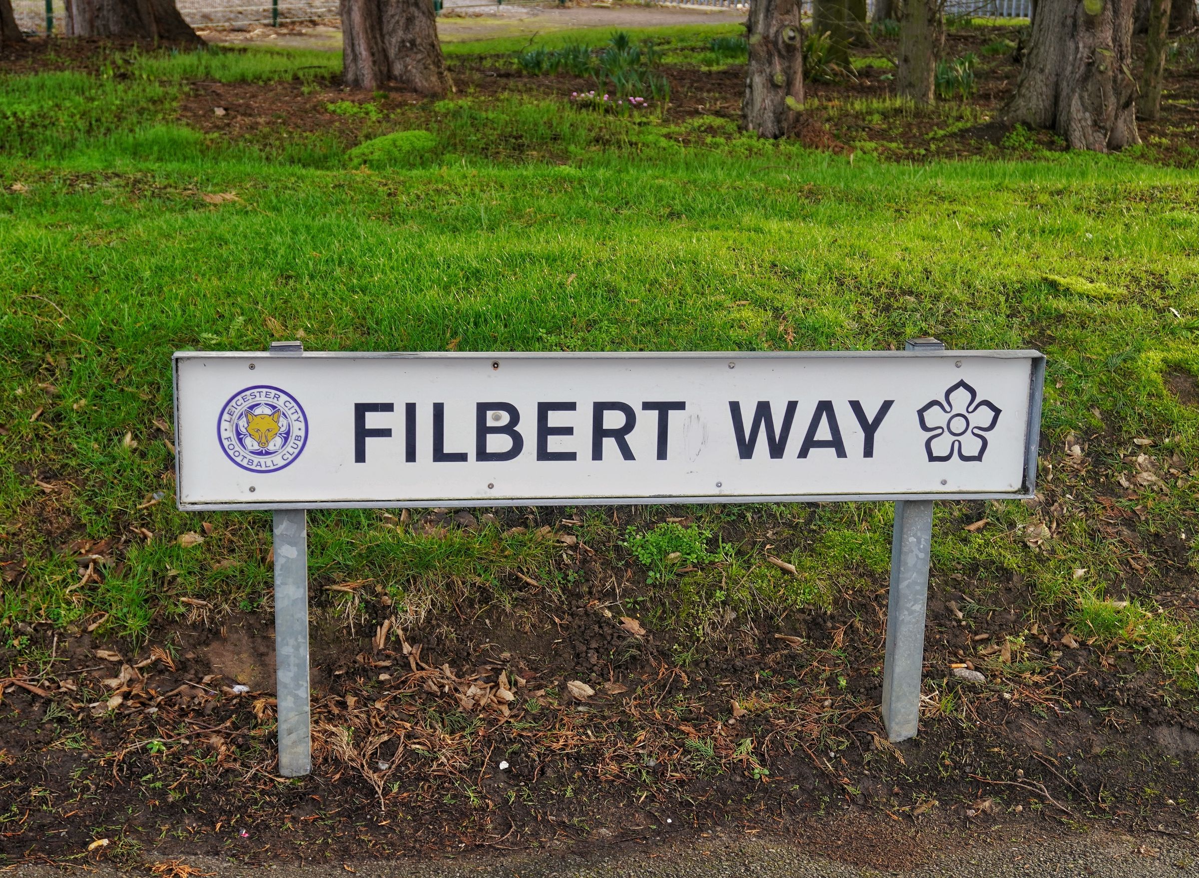 Leicester, UK, February 15, 2026: A white street sign for Filbert Way featuring the Leicester City Football Club crest and a floral emblem outside the King Power Stadium.